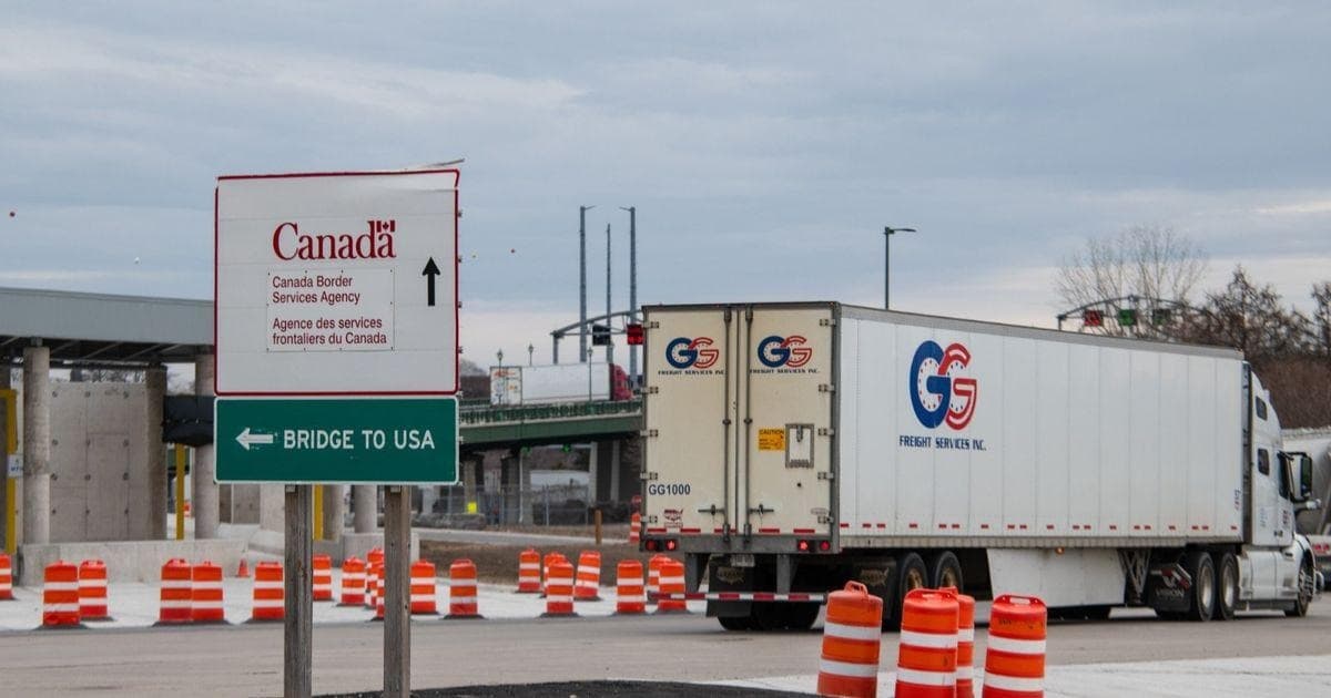 Canada border crossing sign with freight truck headed to the USA